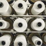 Grandes rolos de papel armazenados em ambiente industrial